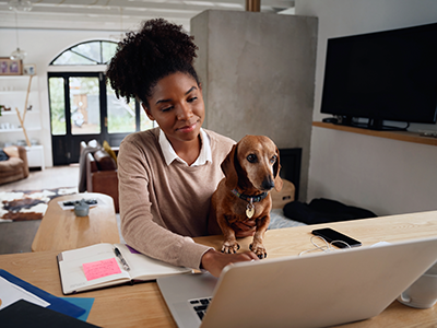 Woman working on laptop with dog