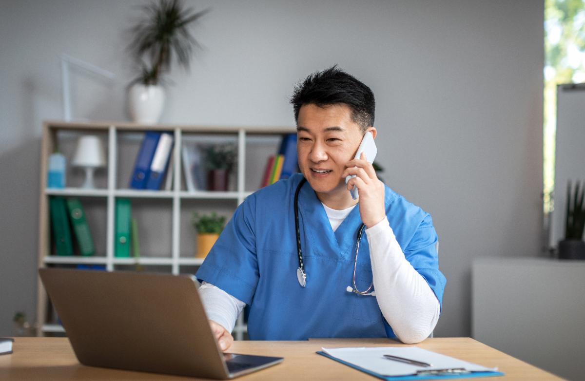 Doctor on phone at his computer.