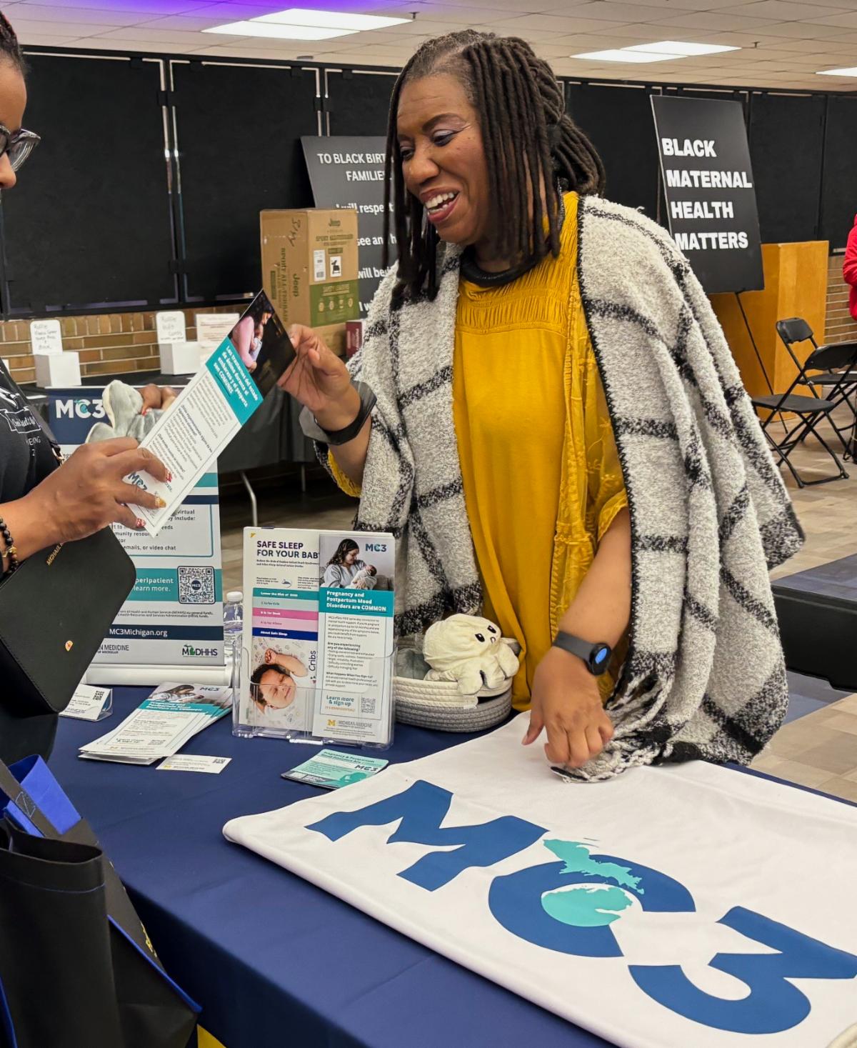 Carmen Harrison interacting with an attendee at the Black Maternal Health Cafe event.