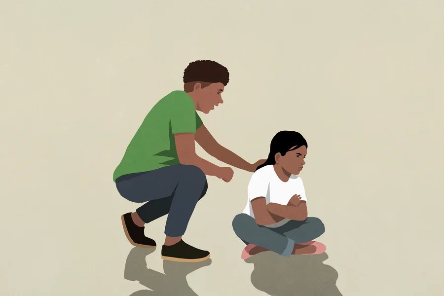Illustration of an upset child sitting on the floor with their parent crouching behind them for comfort.