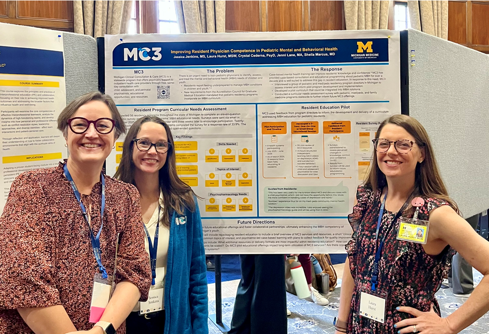 MC3 team members stand in front of their poster at an event.