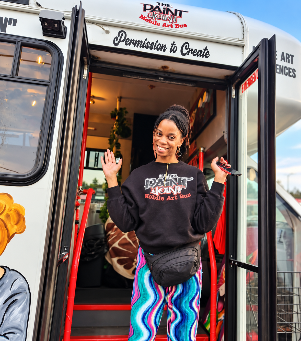 Kay Burnett smiling in the doorway of her Mobile Art Bus