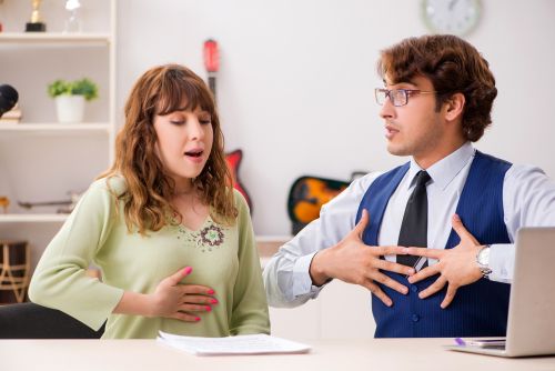 Young woman during music lesson with male teacher