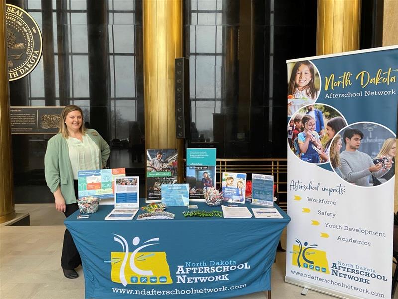Kristin Knorr standing at a booth for the North Dakota Afterschool Network