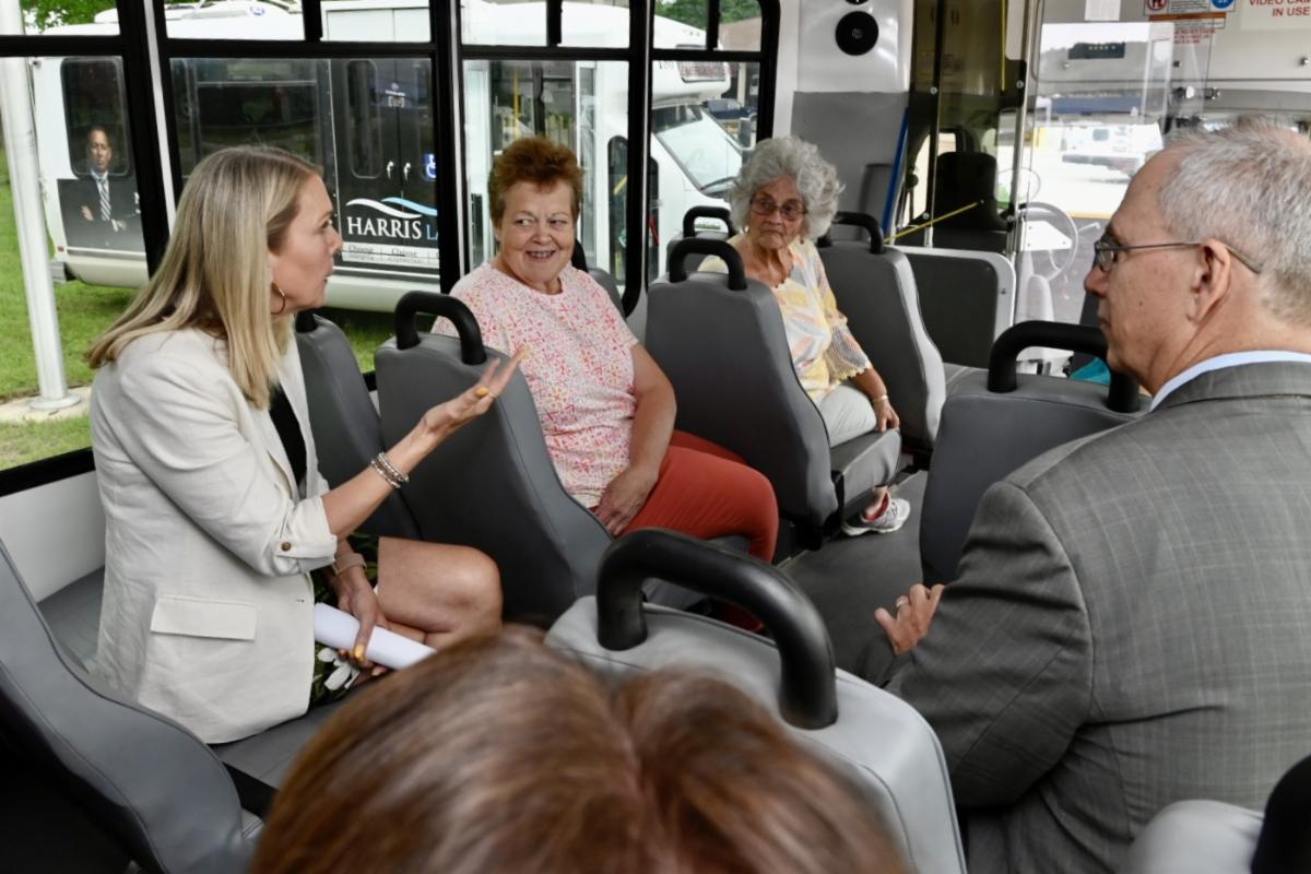 A group of people sitting on a bus and talking. 