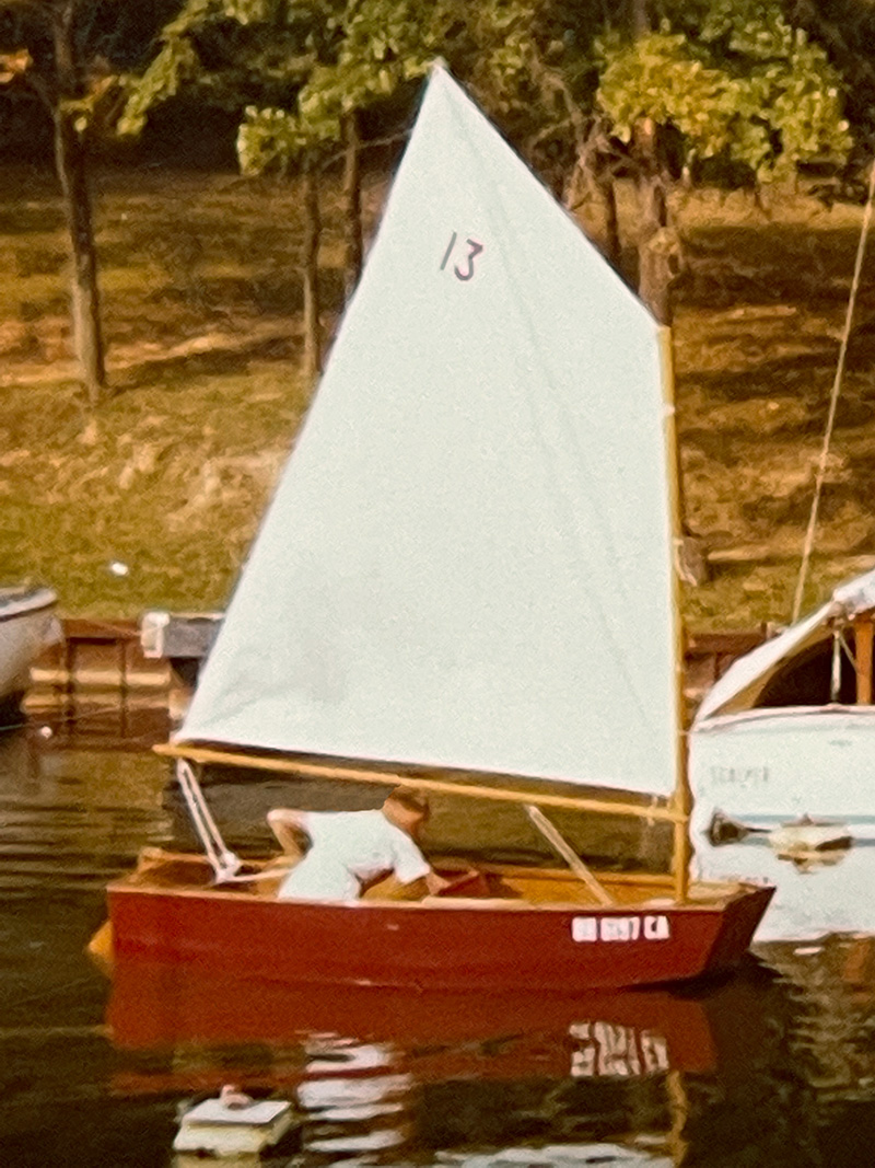 Steve Malton sailing his fixed up Optimist dinghy with sail number 13.