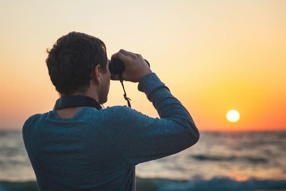 Man scanning the horizon with binoculars