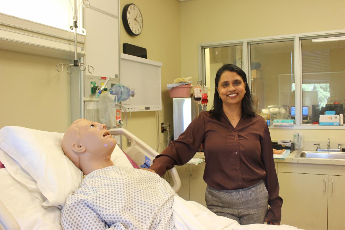 LAVC Nursing Department Chair Dr. Preetha Puthiakunnel poses with a patient mannequin