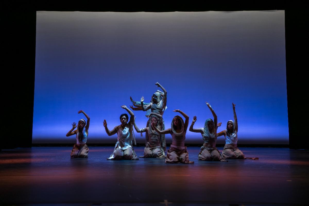 Dancers perform in blue light. Back: Isabella Rosas  Front, Left to Right: Jocelyn Tapia Gaviño, John Orap, Alma Sanchez, Kacey Azucar, Johana Monterosso, Eva Baños