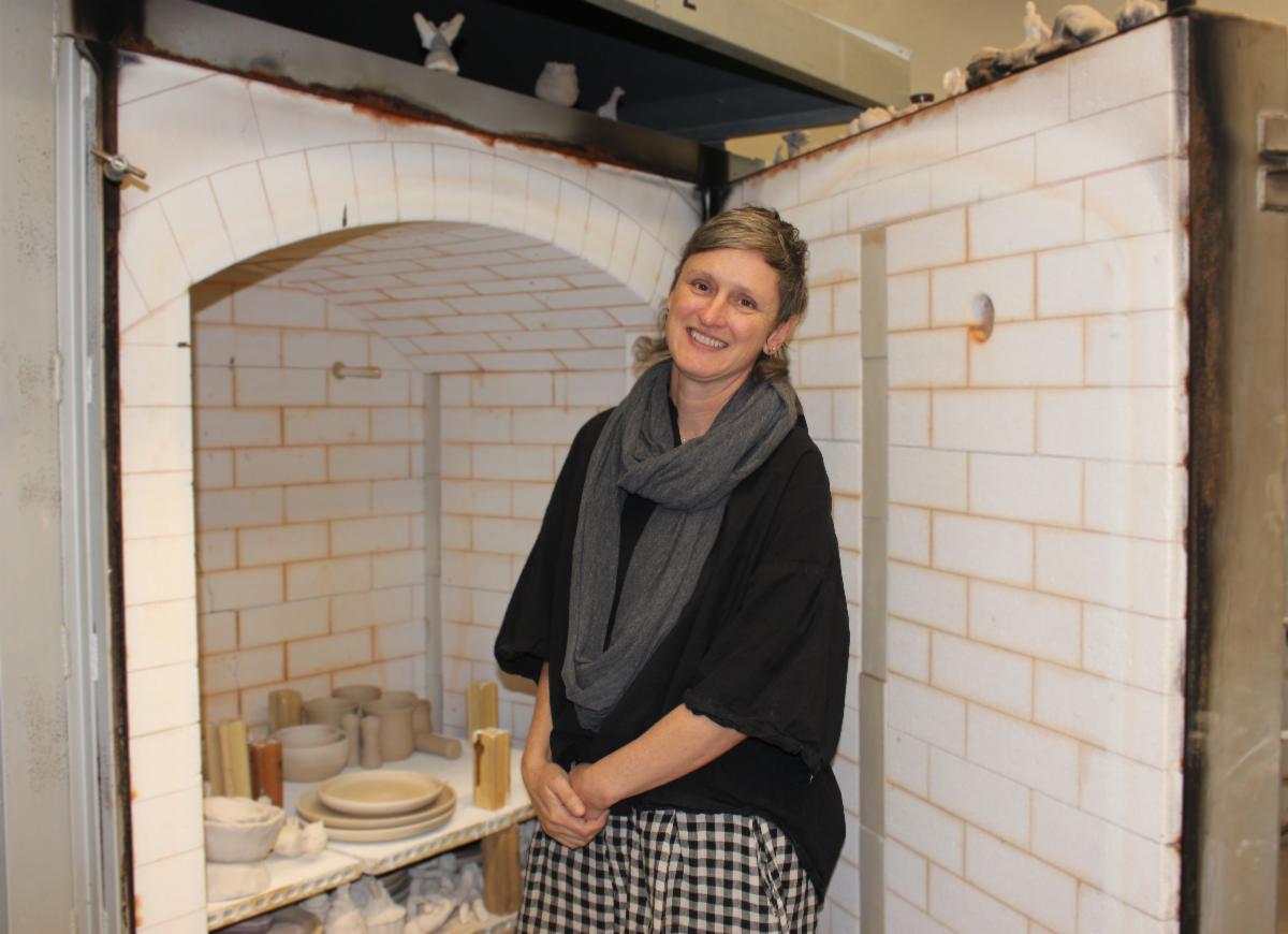 Ceramics Professor Kathryn Queen standing in front of LAVC's Kiln