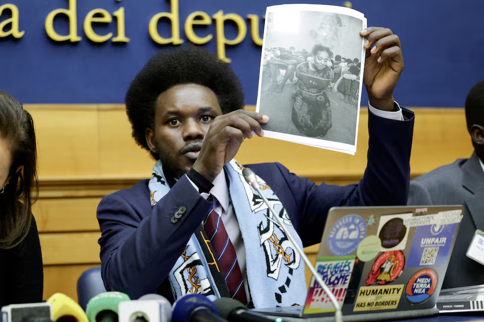 South Sudanese migrant David Yambio, who was allegedly maltreated by Libyan ICC suspect Osama Elmasry Njeem, shows a picture of Ethiopian woman, Naima Jamal, said to have been kidnapped and tortured by traffickers in Libya, as he holds a press conference with other migrants who were allegedly maltreated, at the Parliament in Rome, Italy, January 29, 2025. REUTERS/Remo Casilli