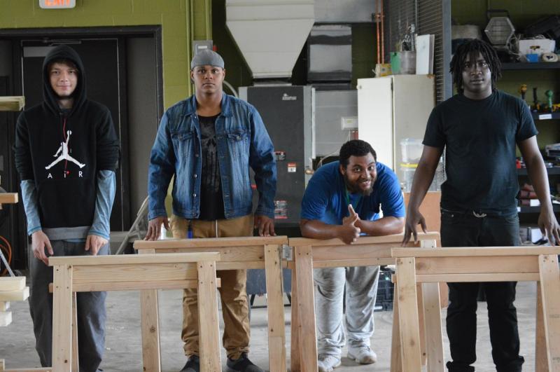 YouthBuild students show off the saw horses they constructed