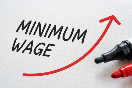 White paper written  MINIMUM WAGE  with markers.