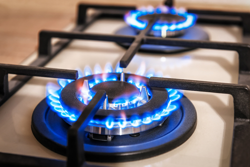 Closeup shot of blue fire from domestic kitchen stove top. Gas cooker with burning flames of propane gas. Industrial resources and economy concept.