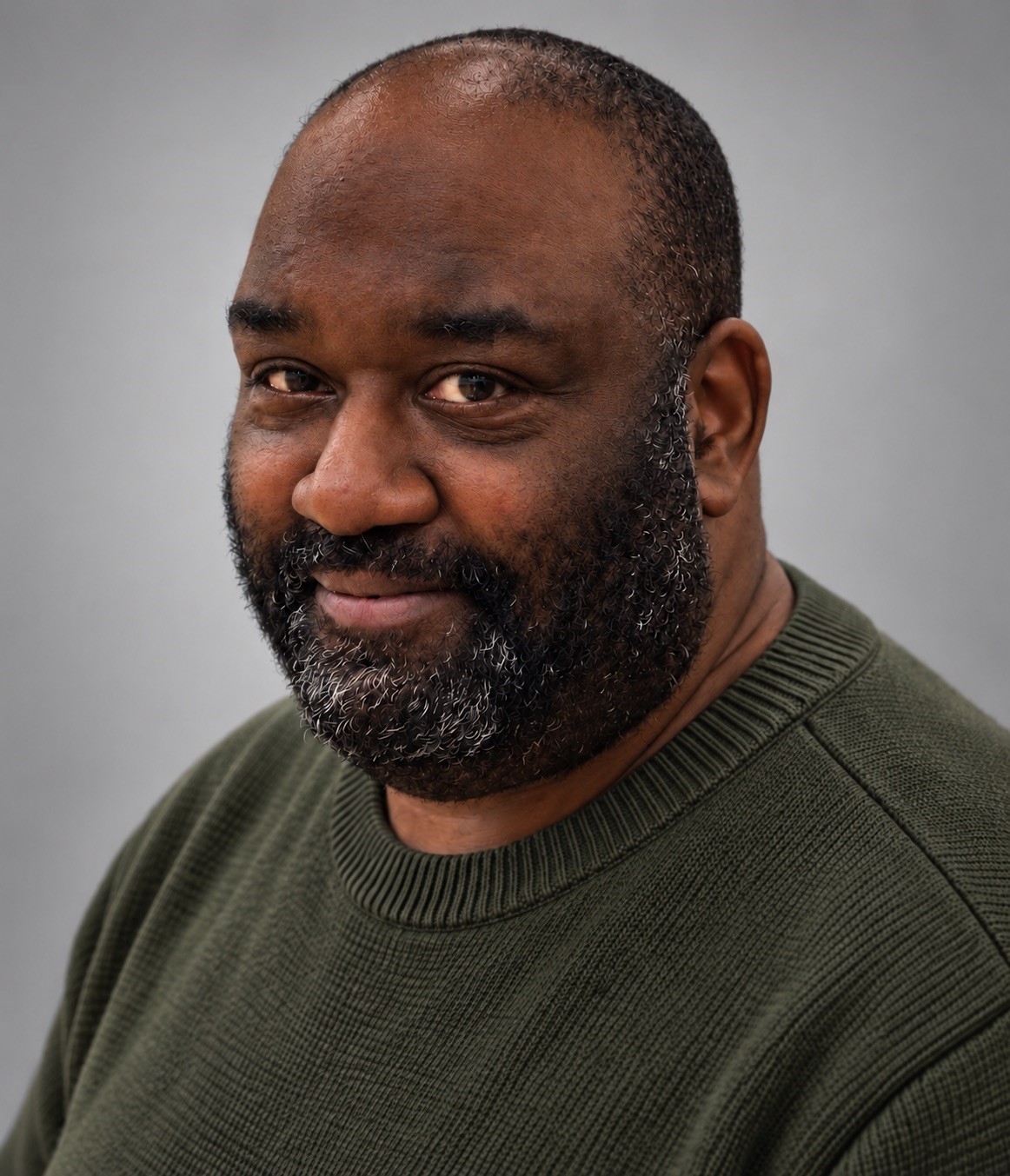 Headshot of Coach Andre Stewart in green-gray sweater