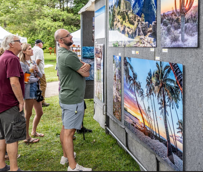 People viewing artwork posted on an outdoor display