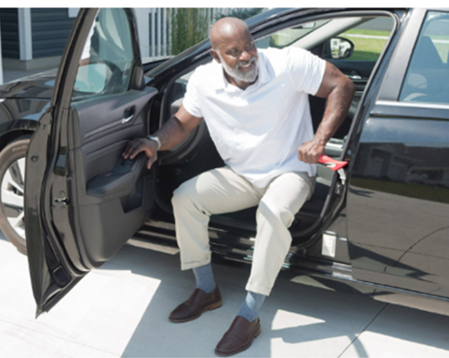 Older Black men exiting car with help of Handybar attached to car 