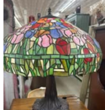 Antique lamp on a table at the Antique Mall, with other furniture items in background