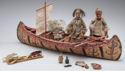 Indigenous dolls and model canoe with sail from Turtle Island exhibit