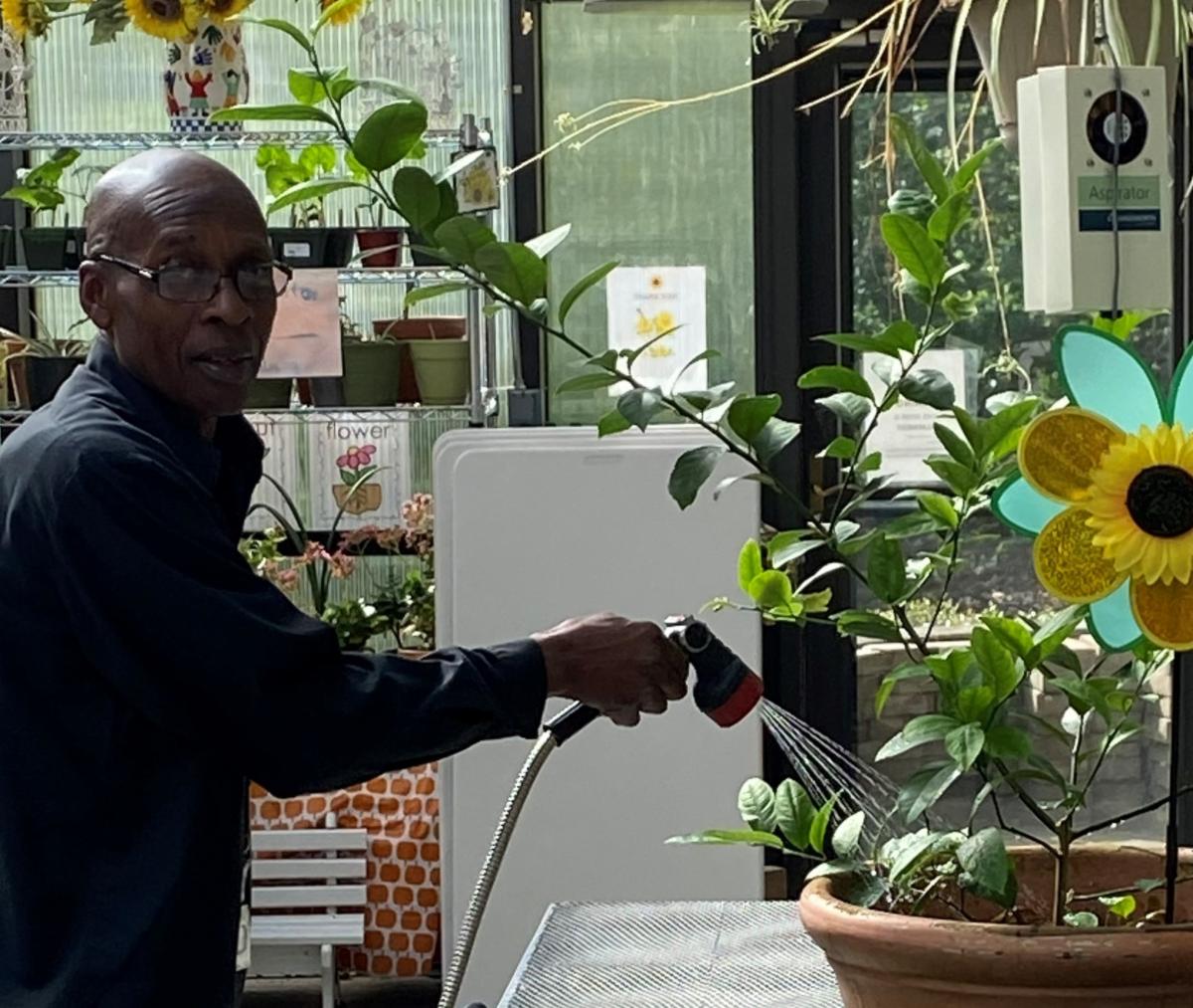 NEWAmysGreenhousePhotoWithCustodianDerrickBurfordPhoto.jpg