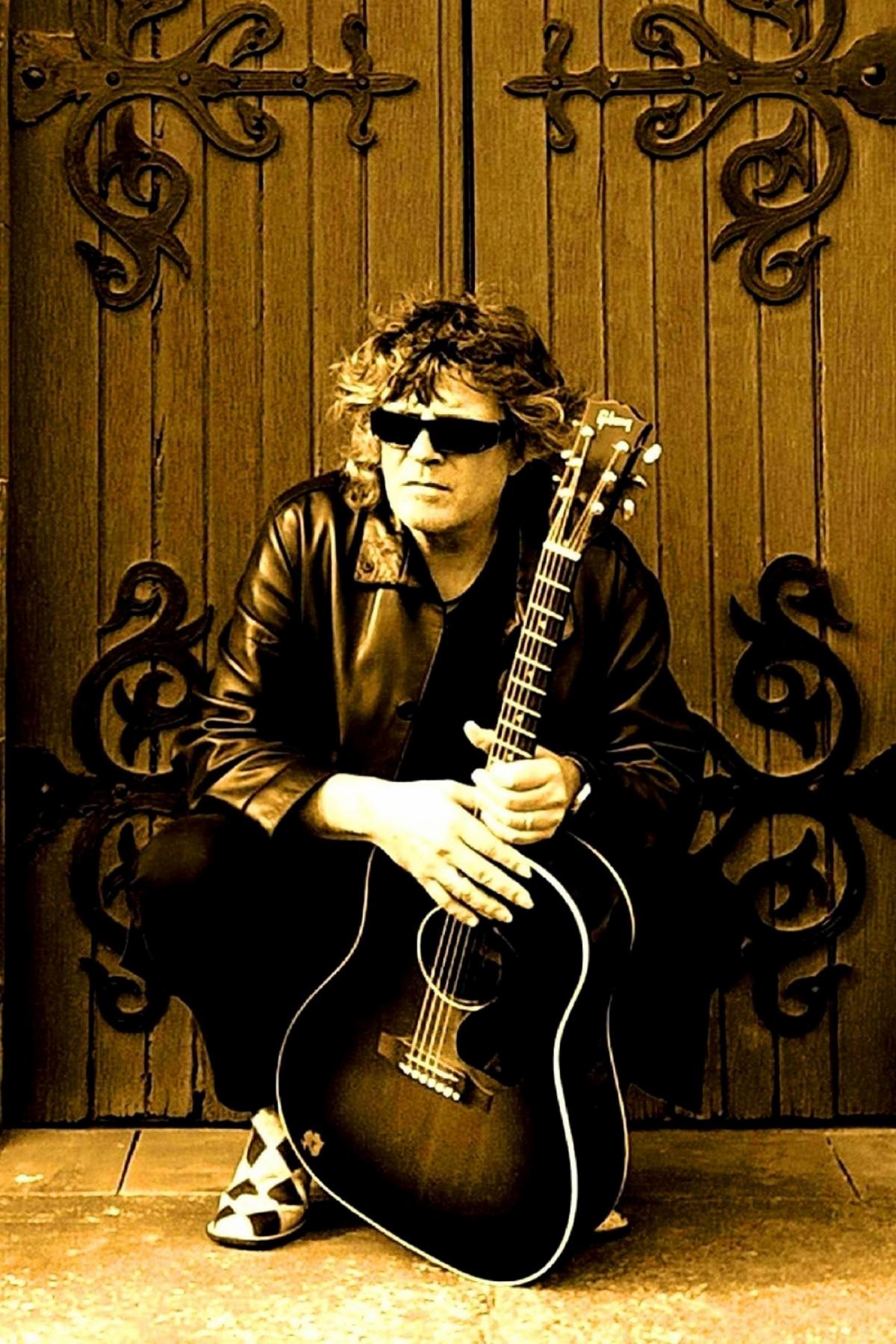 Photo of Claude Bourbon holding his guitar