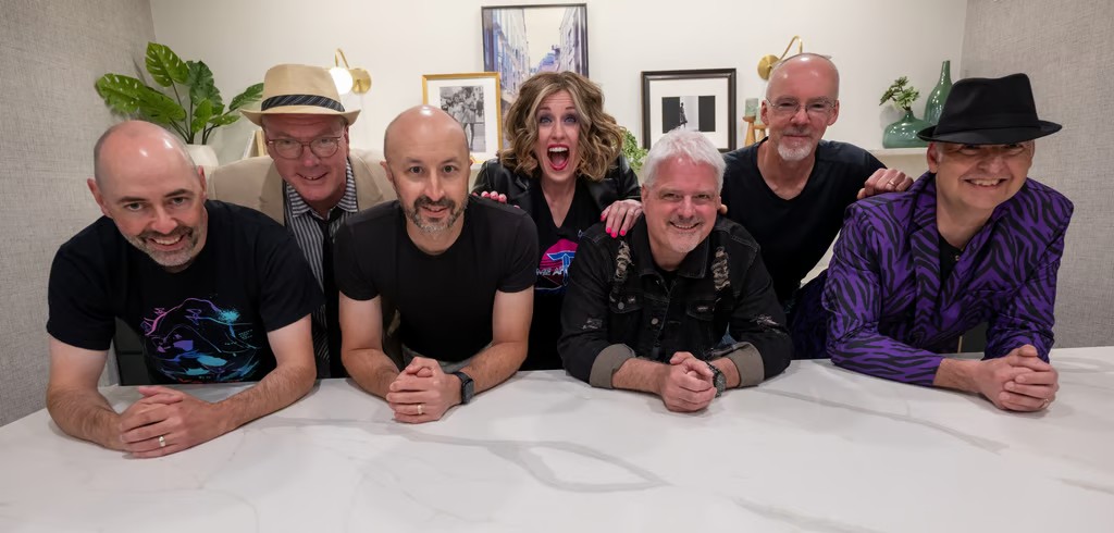The members of the 80s tribute band Time after Time smiling at the camera.