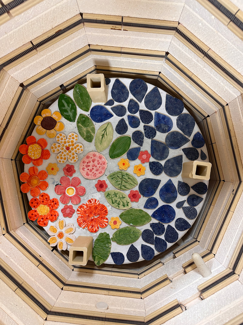 Brightly glazed tiles in the shape of flowers and water drops at the bottom of a kiln.