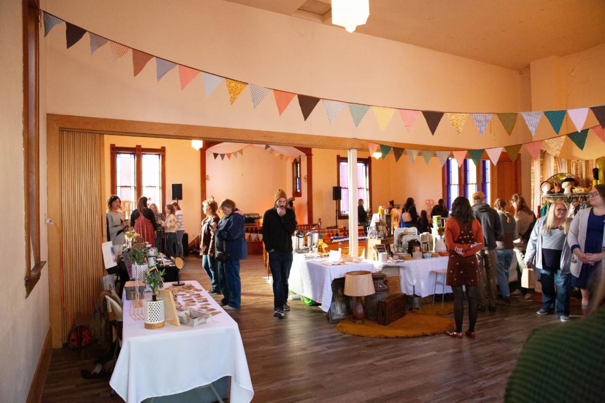People at a previous Vintage and Makers Market at Mainspring looking at artist's tables.