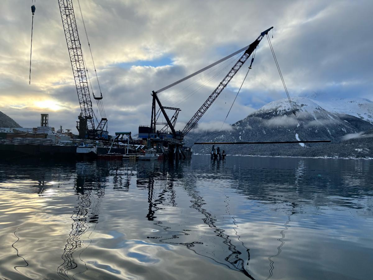 Shot of barge in water in front of mountain range