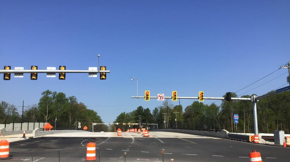 Photo of Georgetown Pike bridge over I-495 in McLean, VA, facing west. Newly opened southern portion of bridge is shown and median of bridge is surrounded by orange construction barrels.