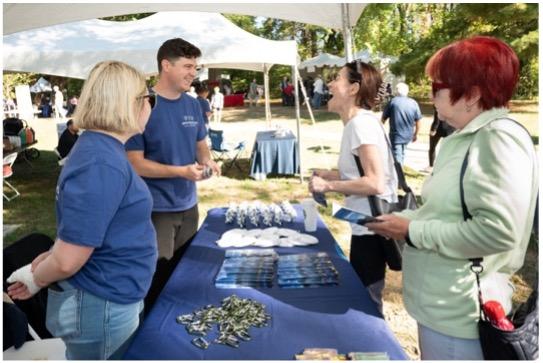 Photo of four people standing at a table with 495 Express Lanes informational materials sitting on table.