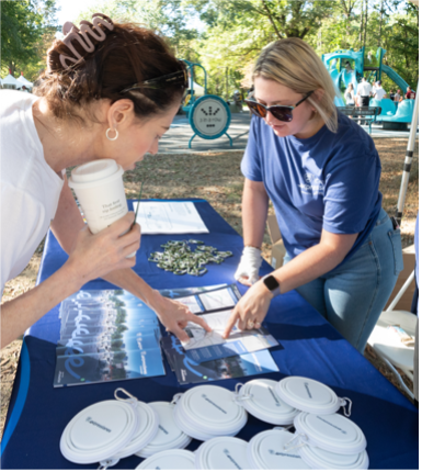Photo showing two people standing over a table with 495 Express Lanes information materials.