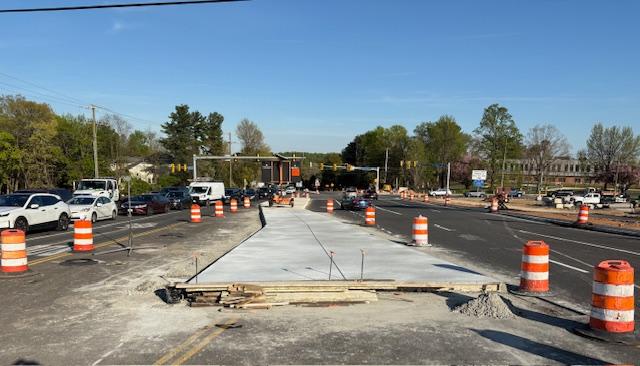 Photo of Georgetown Pike roadway facing east near the Balls Hill Road intersection in McLean, VA. Orange construction barrels surround an in-progress concrete median dividing opposing lanes of traffic.