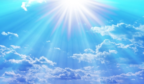 Easter background with a shining star and blue sky with white clouds.