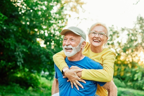 Smiling active senior couple having fun  together in the park_ active healthy elderly people bonding_ older couple happy relationship