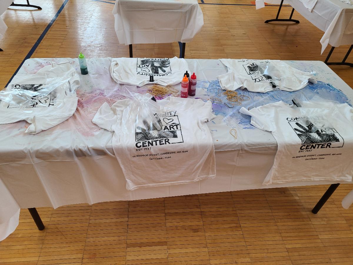 T-shirts laid out on a white table with dye