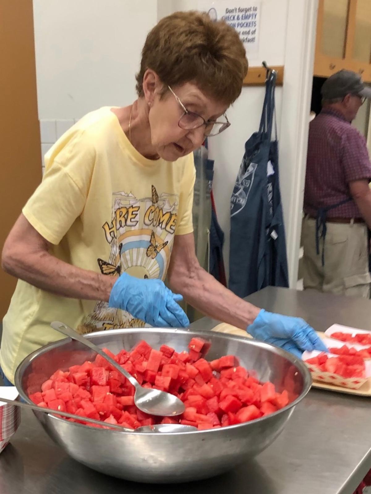 A woman prepares servings of watermelon