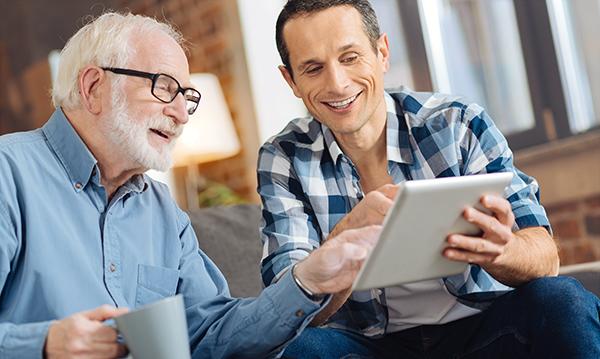Father and son drinking tea using tablet