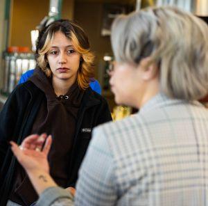 A Student Success Coach speaks with a small group of students, providing guidance about class options and academic planning.