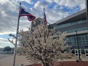 Flag and flowers in front of the Clay Pathfinder Building
