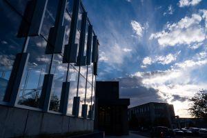 Exterior view of Ludden Library at sunset, with soft clouds in the sky and the Health Science building visible in the background.