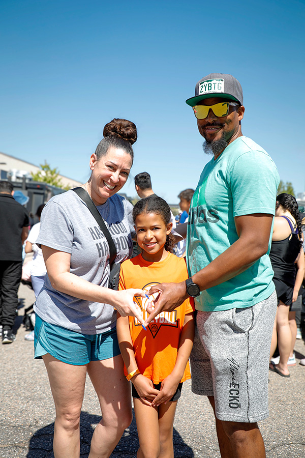 Two parents with their student joining hands in the shape of a heart