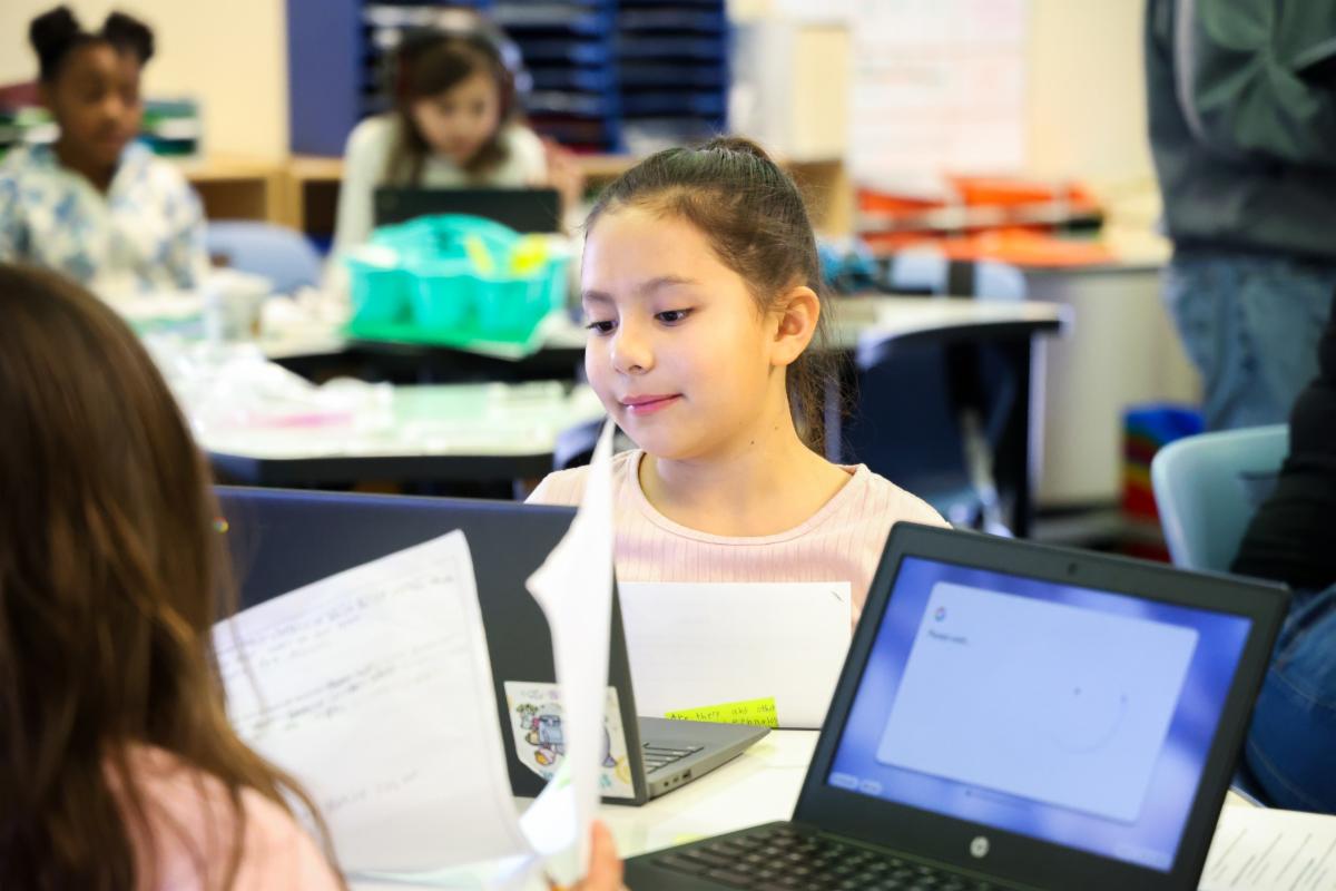 a student in a classroom taking a spring assessment on a laptop