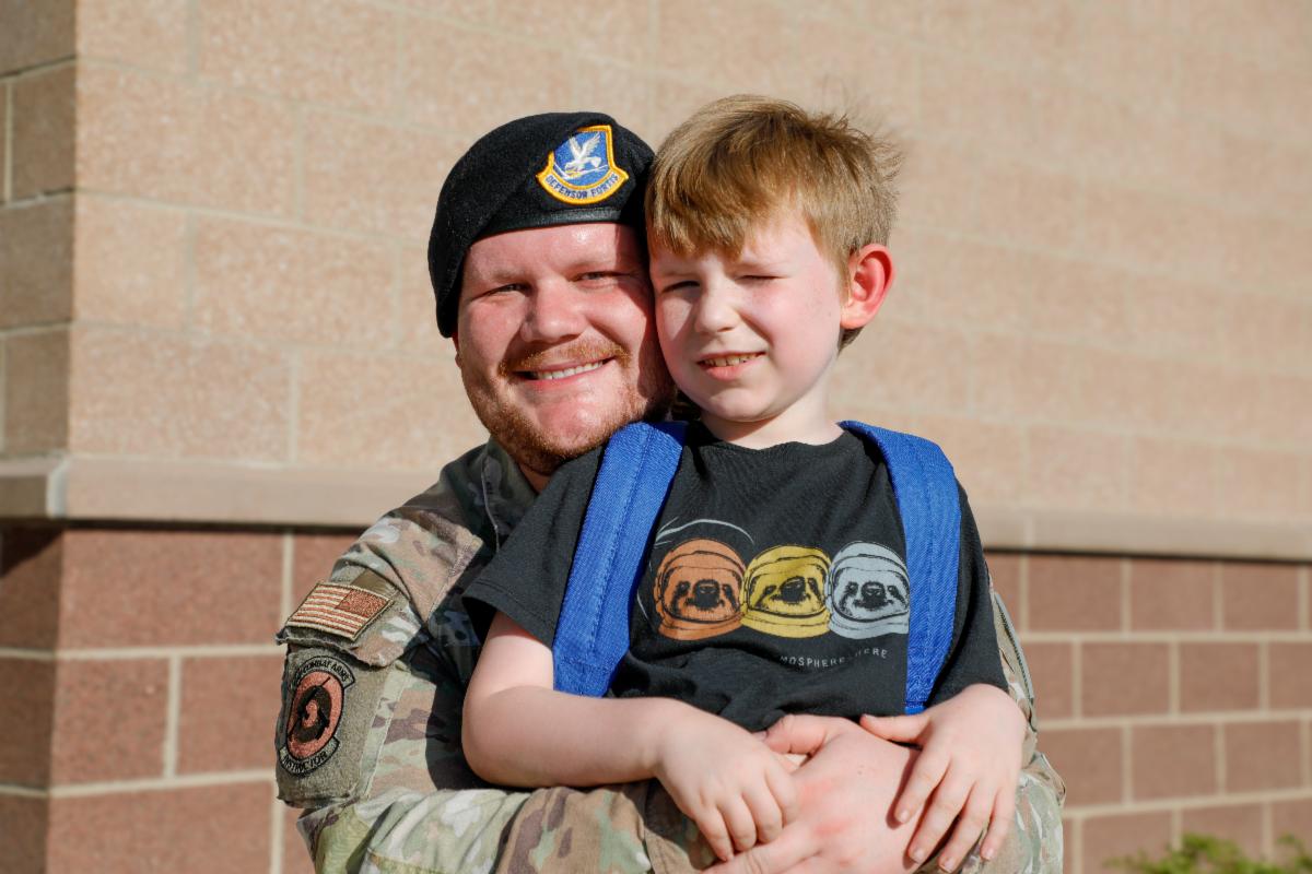 Military member and APS parent hugging their elementary school child. 