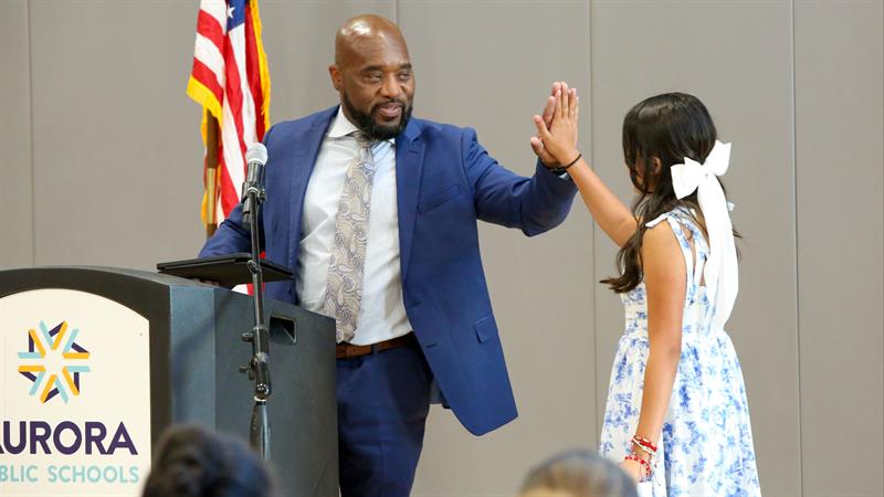 APS Superintendent Michael Giles, Jr. give a high five to a Coal Creek P-8 student who is about to give a speech at the school's grand opening.