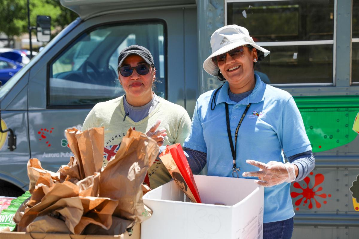 Two community members holding boxes of food