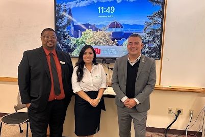 Board President Tramaine Duncan at school board symposium with two members from the University of Denver