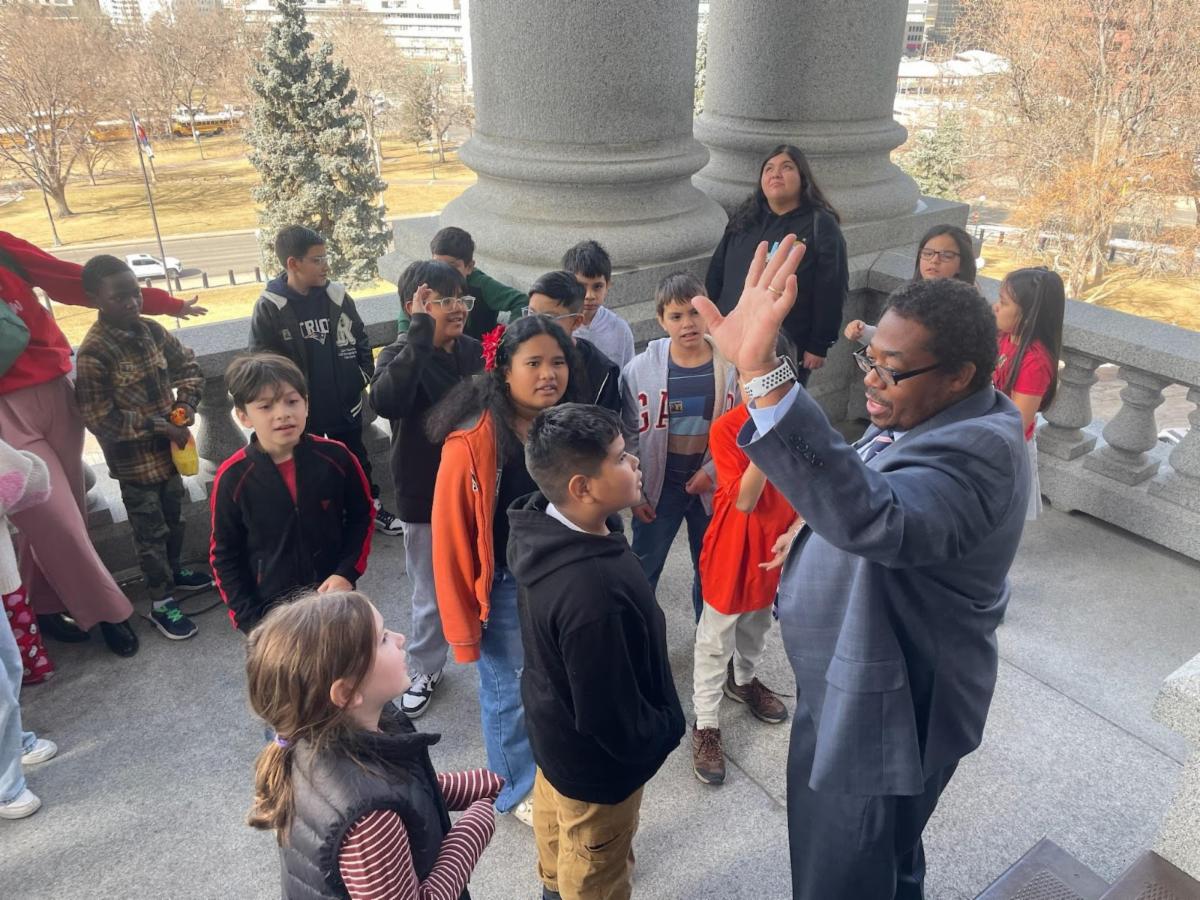 Board Vice President Michael Carter with APS students giving a high five