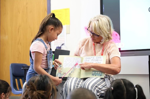 Board Treasurer Vicki Reinhard reads to second-grade students at Kenton Elementary
