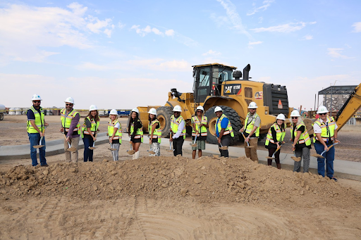parents staff community members breaking ground with shovels
